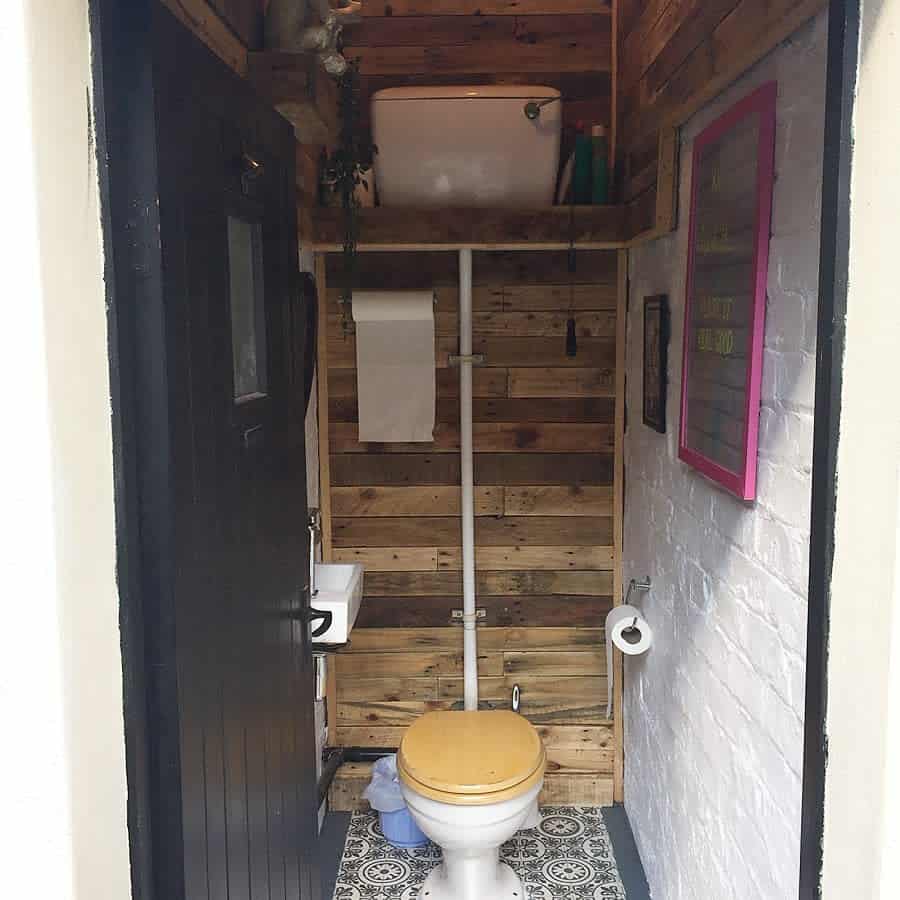 Rustic bathroom with wood walls and patterned floor tiles