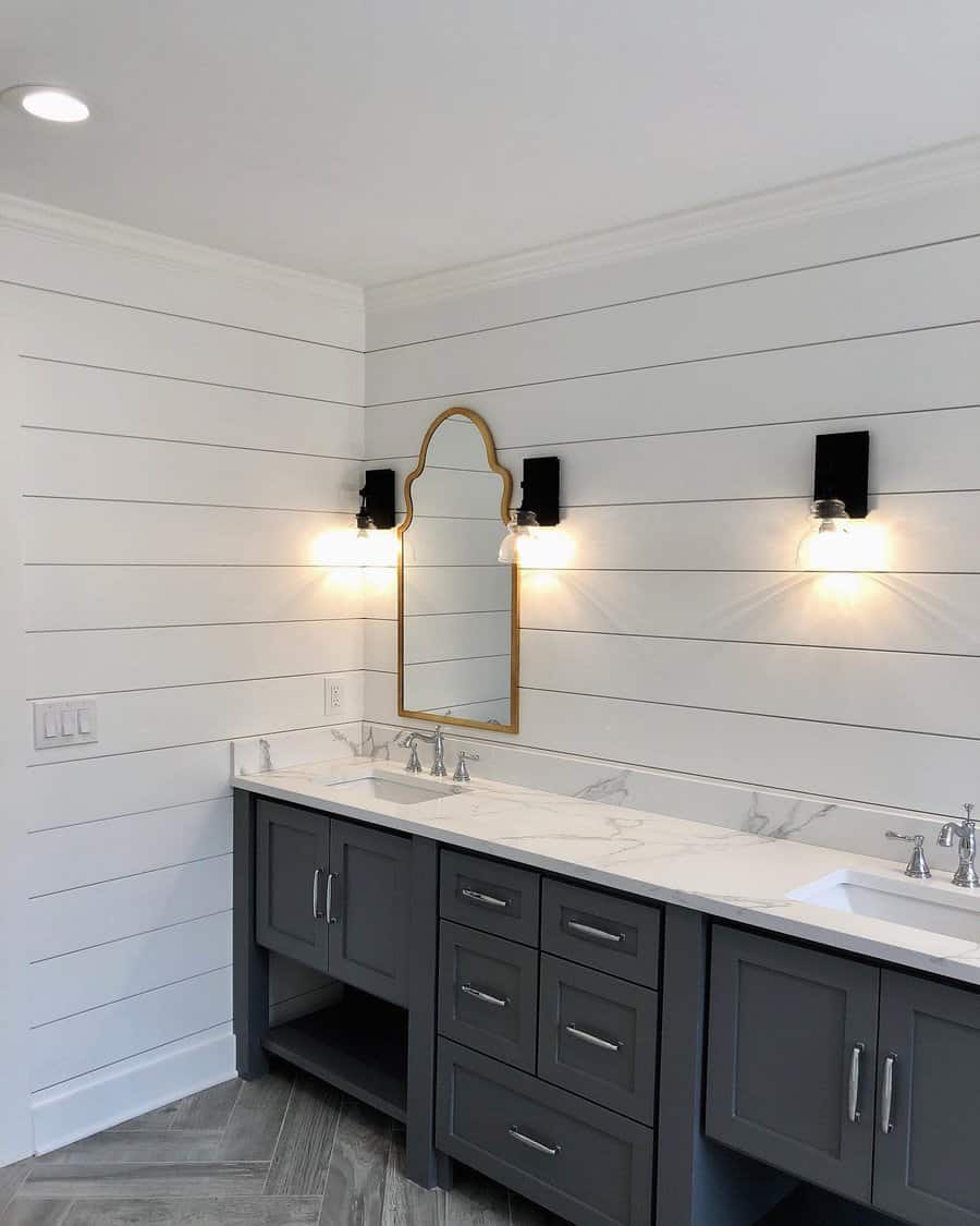 Bathroom with shiplap walls and gold framed mirror