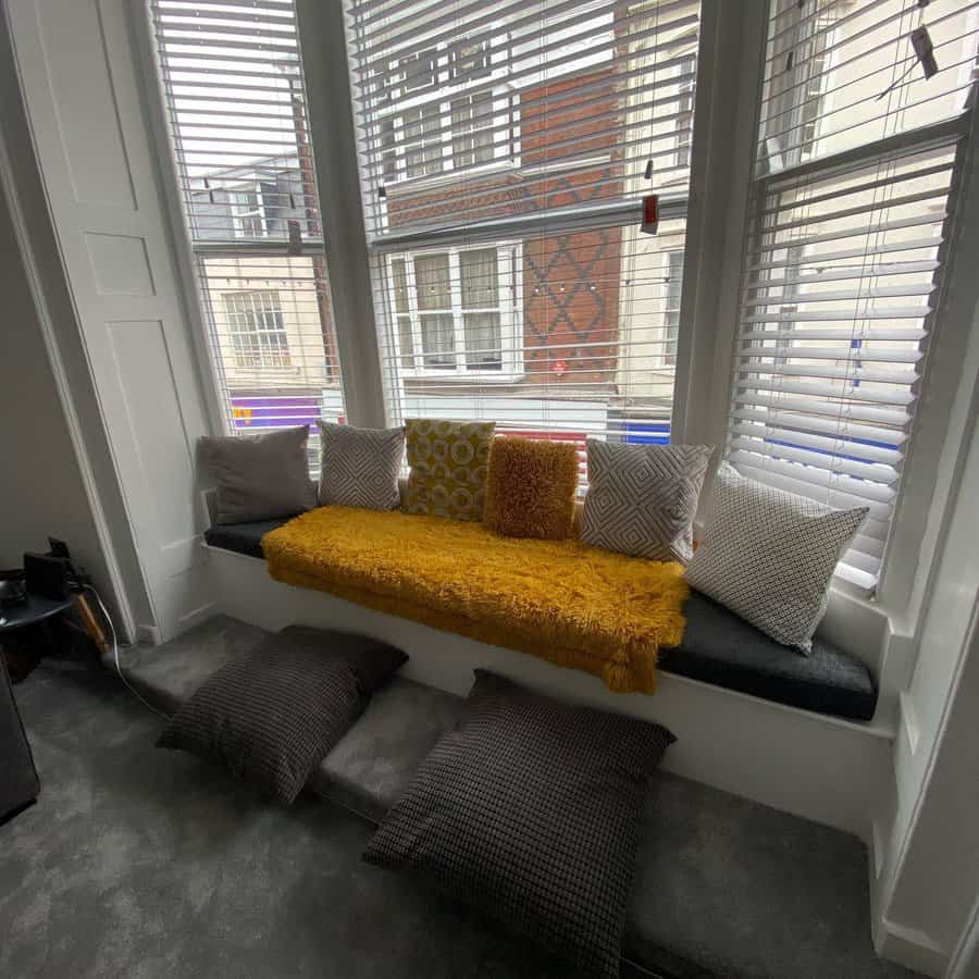 Cozy bay window seat with colorful cushions and pillows