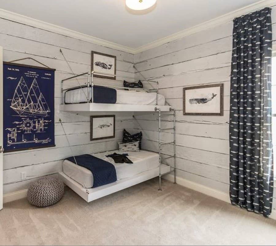 Nautical-themed bedroom with bunk beds, whale art, a blueprint poster, and dark whale-patterned curtains, carpeted floor and cushion