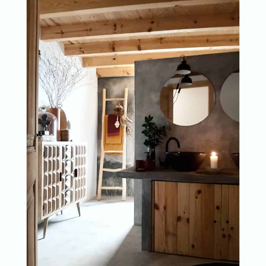 Rustic bathroom with exposed wooden beams, concrete accents, and warm lighting, creating a cozy and inviting atmosphere with natural textures.