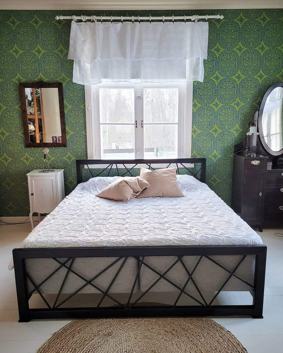 Bedroom with patterned wallpaper and metal bed frame