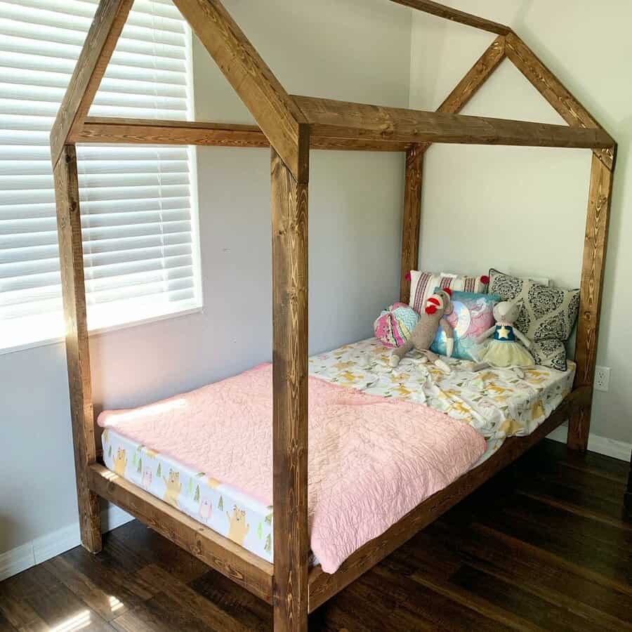 Wooden bed shaped like a house with colorful bedding