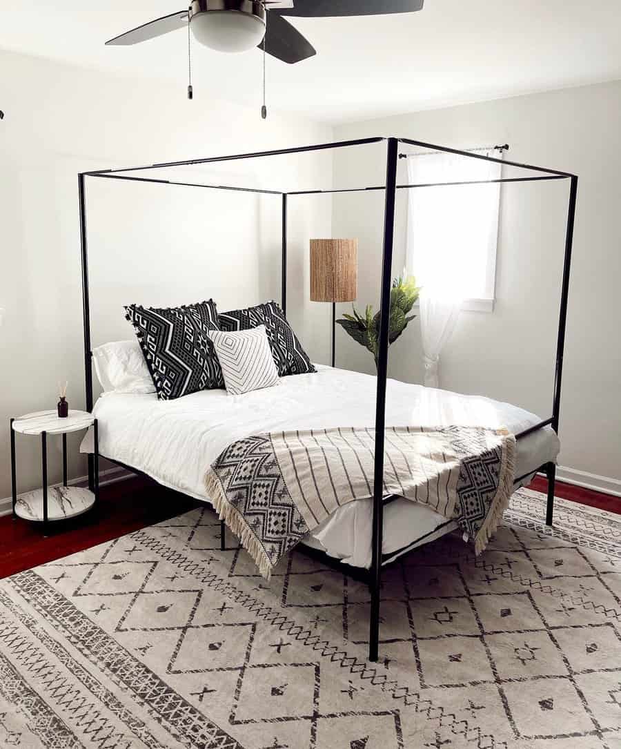 Modern canopy bed with geometric bedding and patterned rug