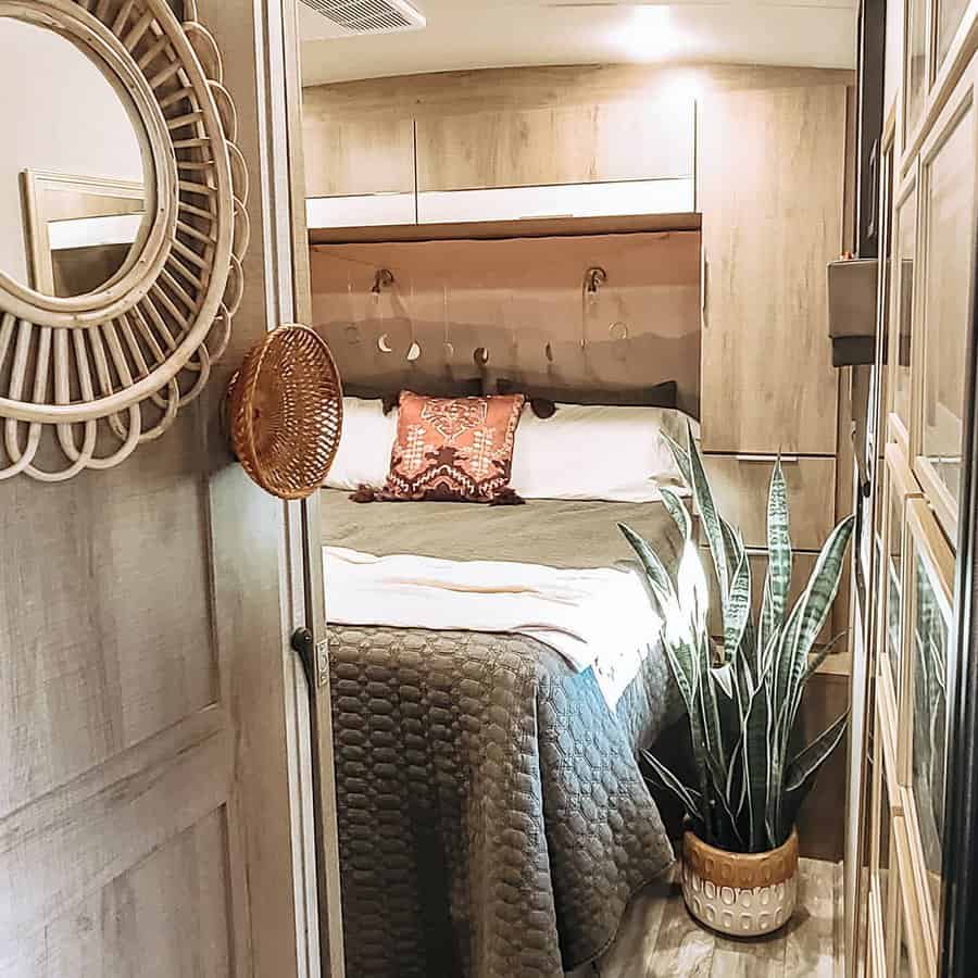 Modern RV bedroom with stylish mirror and plant decor