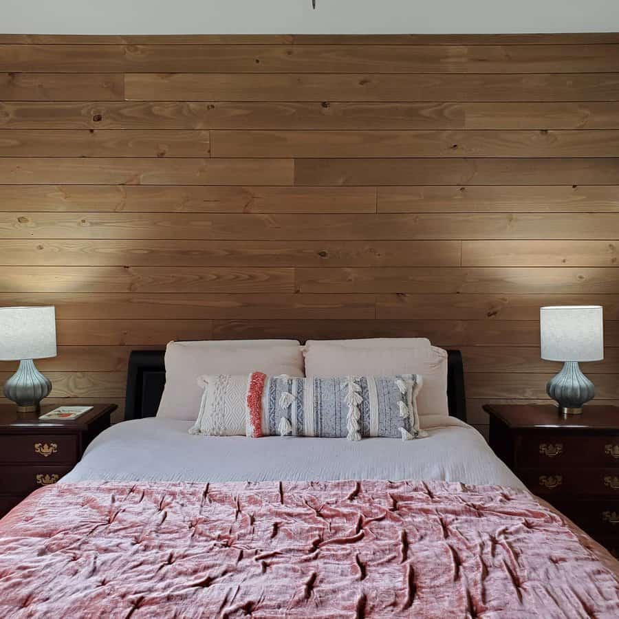 Bedroom with wooden wall and cozy bedding