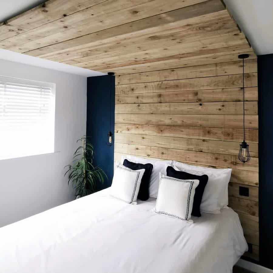 Minimalist bedroom with a wood pallet wall and pendant lights