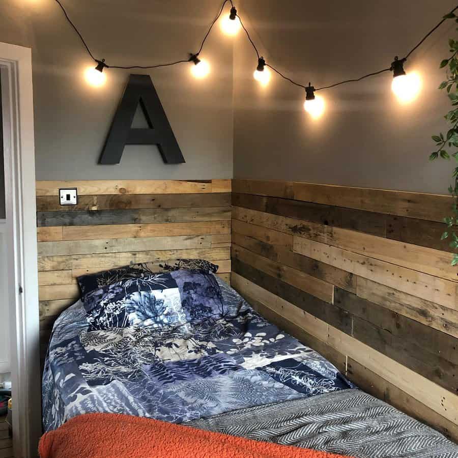 Cozy bedroom corner with pallet wall and string lights