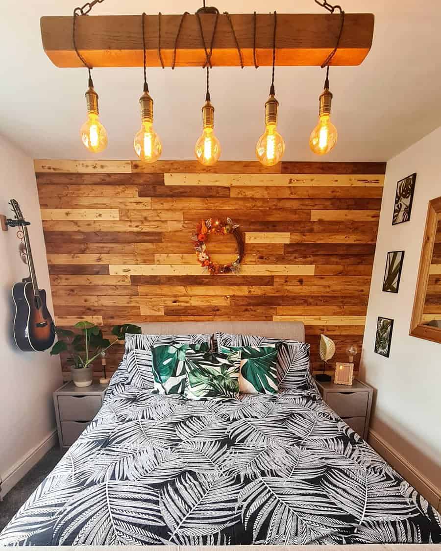 Tropical themed bedroom with wood pallet wall and Edison lights