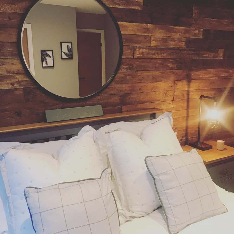 Inviting bedroom with rustic pallet wood wall and round mirror