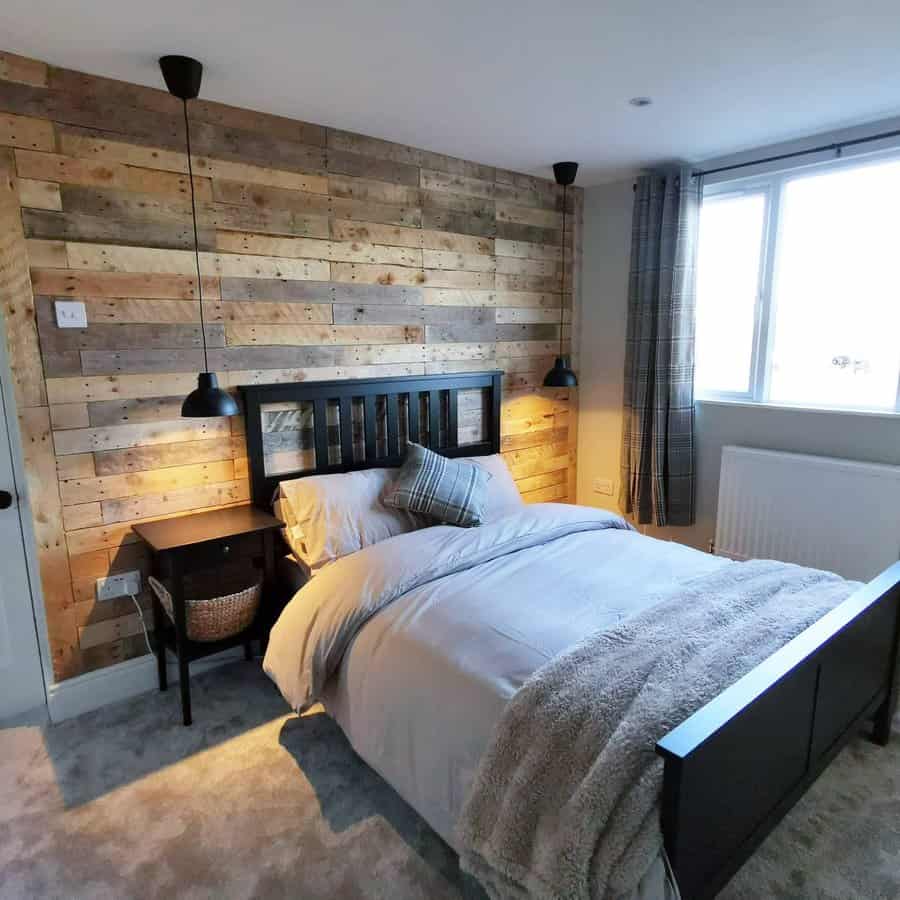 Contemporary bedroom with a reclaimed pallet wall and pendant lights