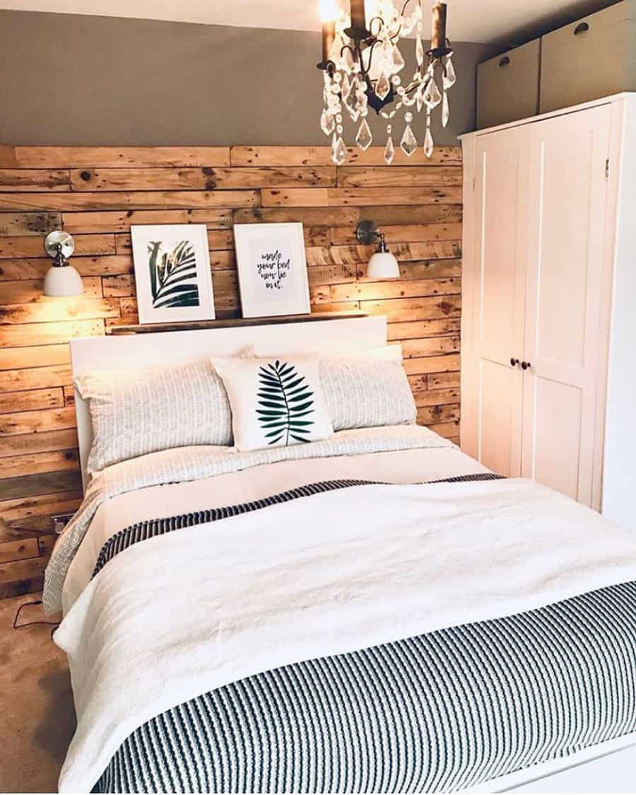 Chic bedroom with pallet wall, chandelier, and botanical art