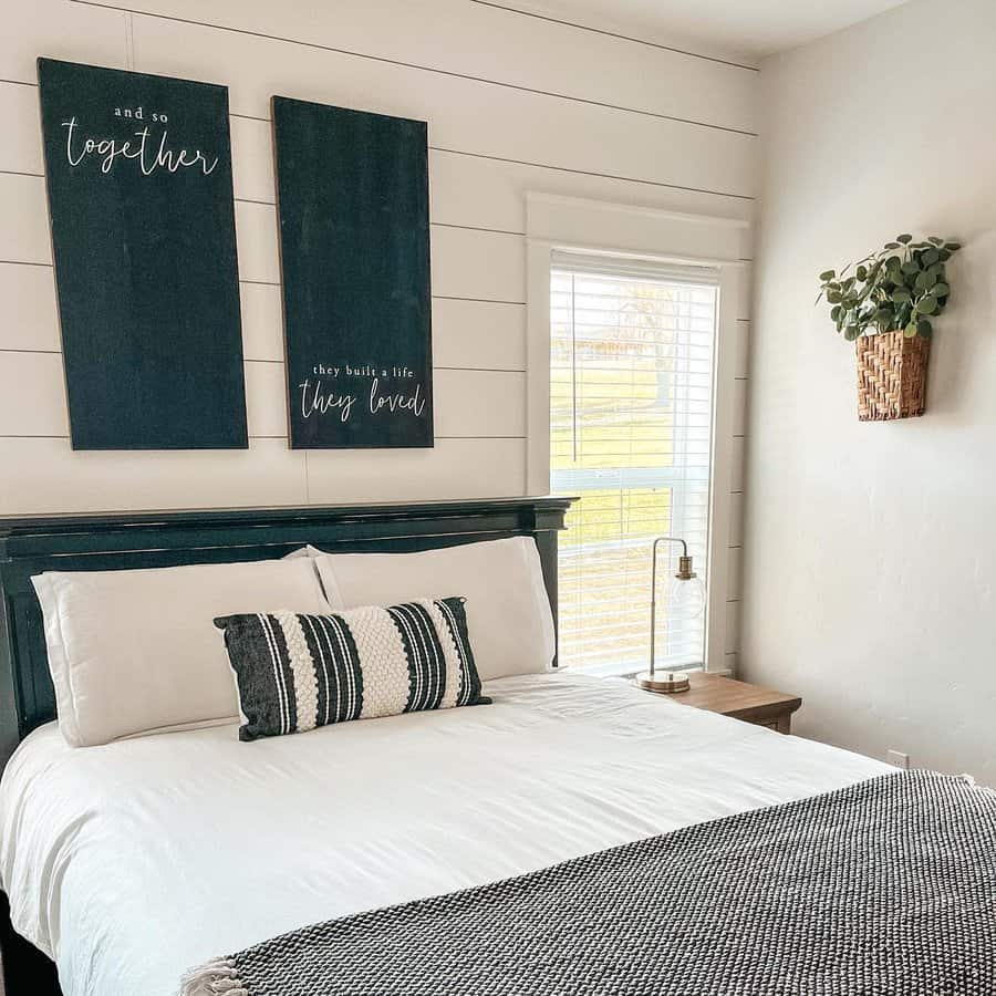 Bedroom with shiplap wall and inspirational art