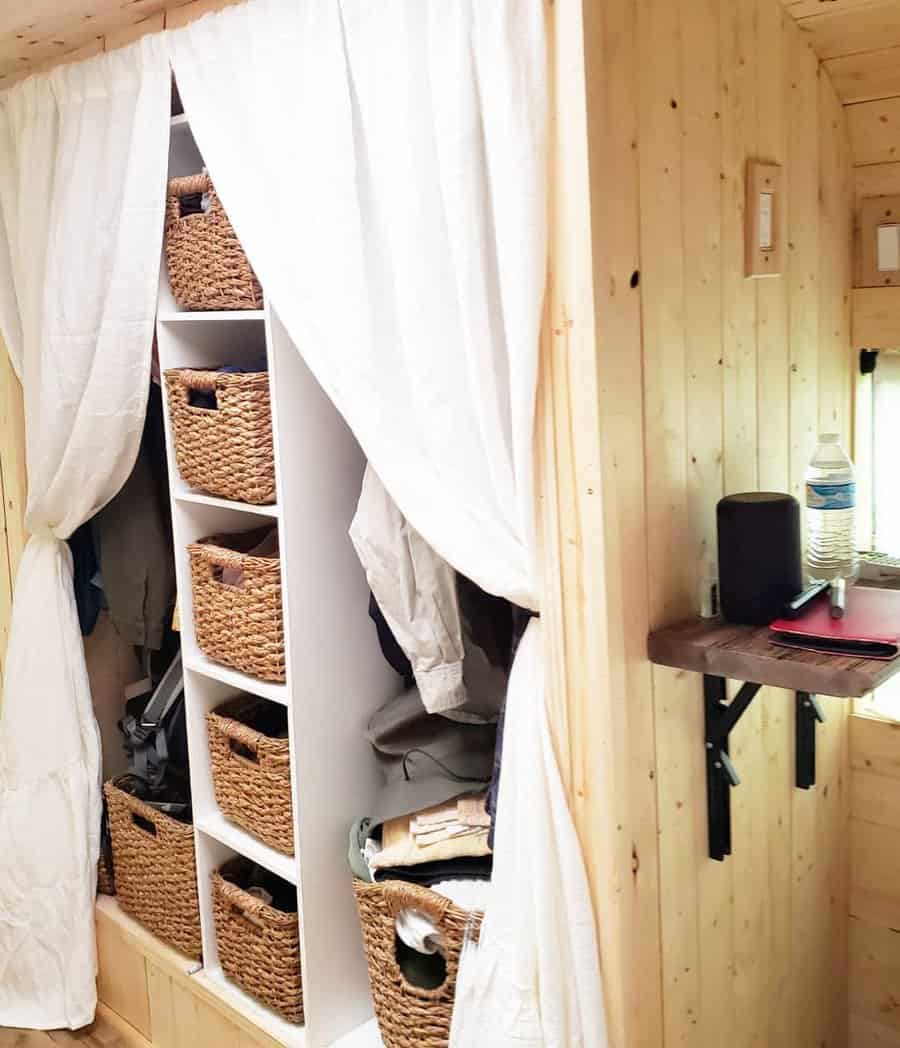 Rustic closet with wicker baskets and white curtains