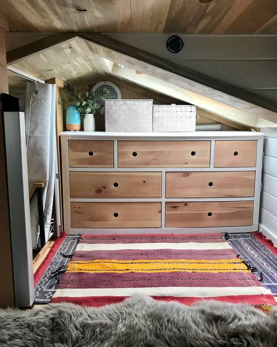 Loft bedroom with a colorful rug and wooden dresser