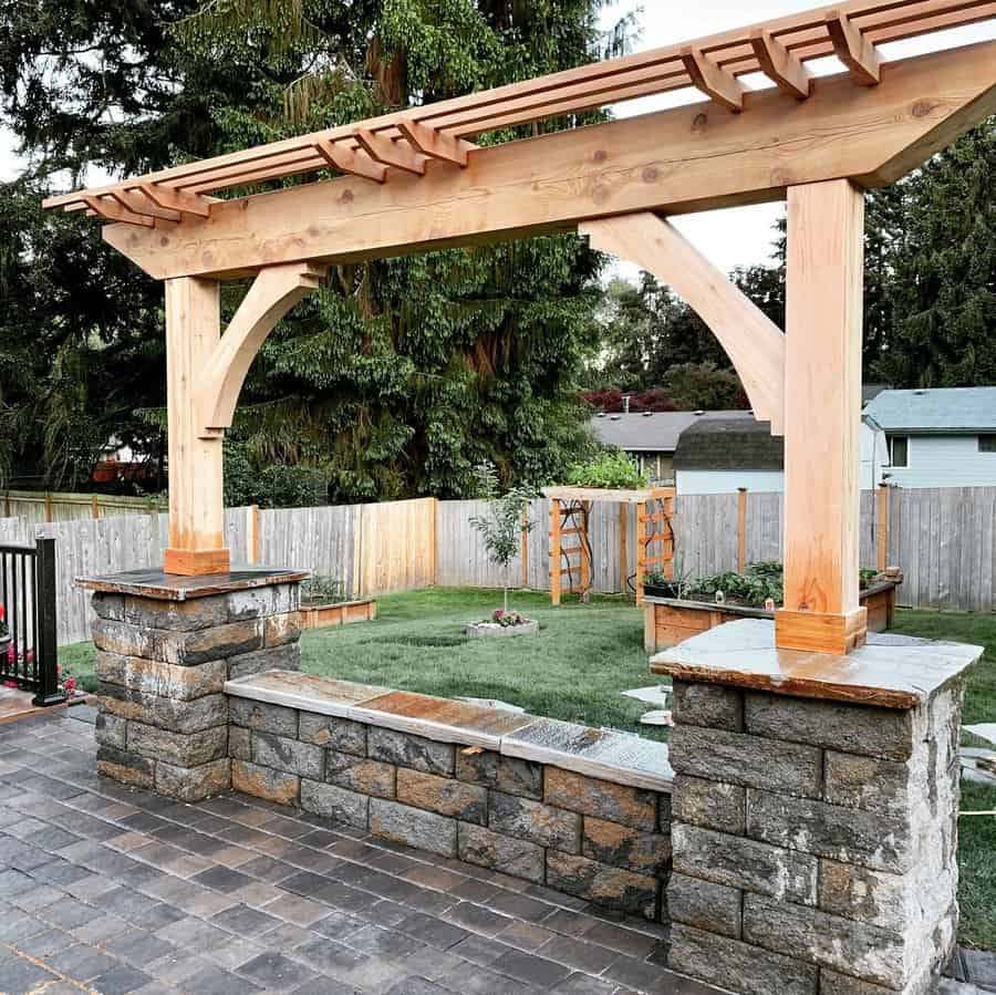 Stone patio with wooden pergola and garden