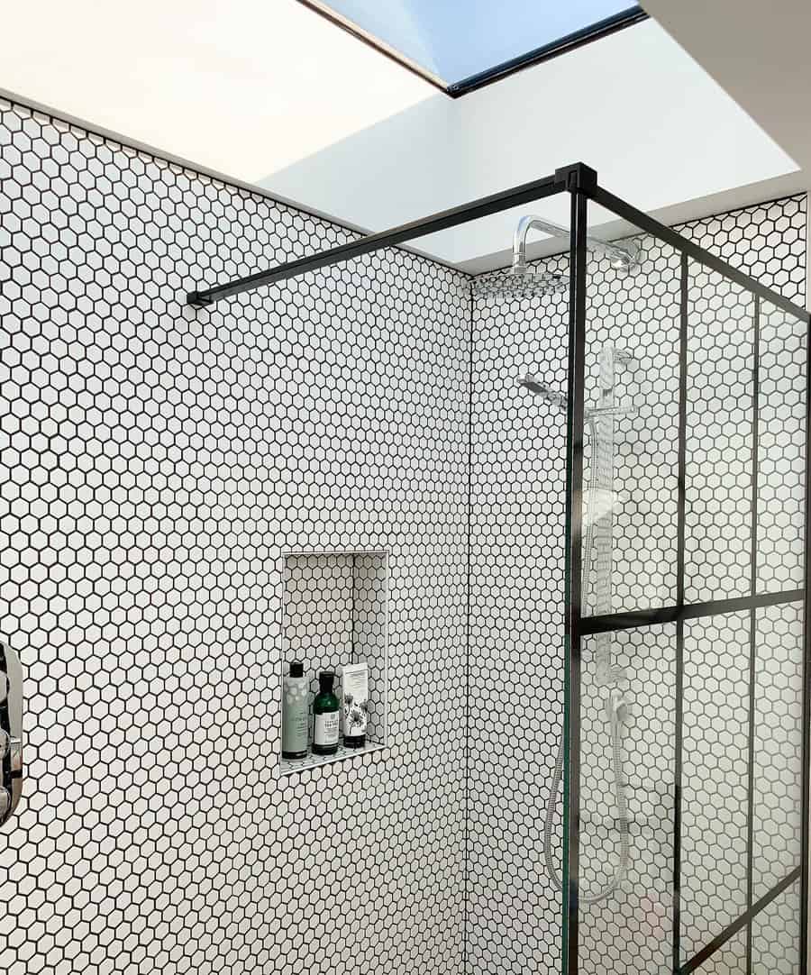 Walk in shower with black and white subway tile