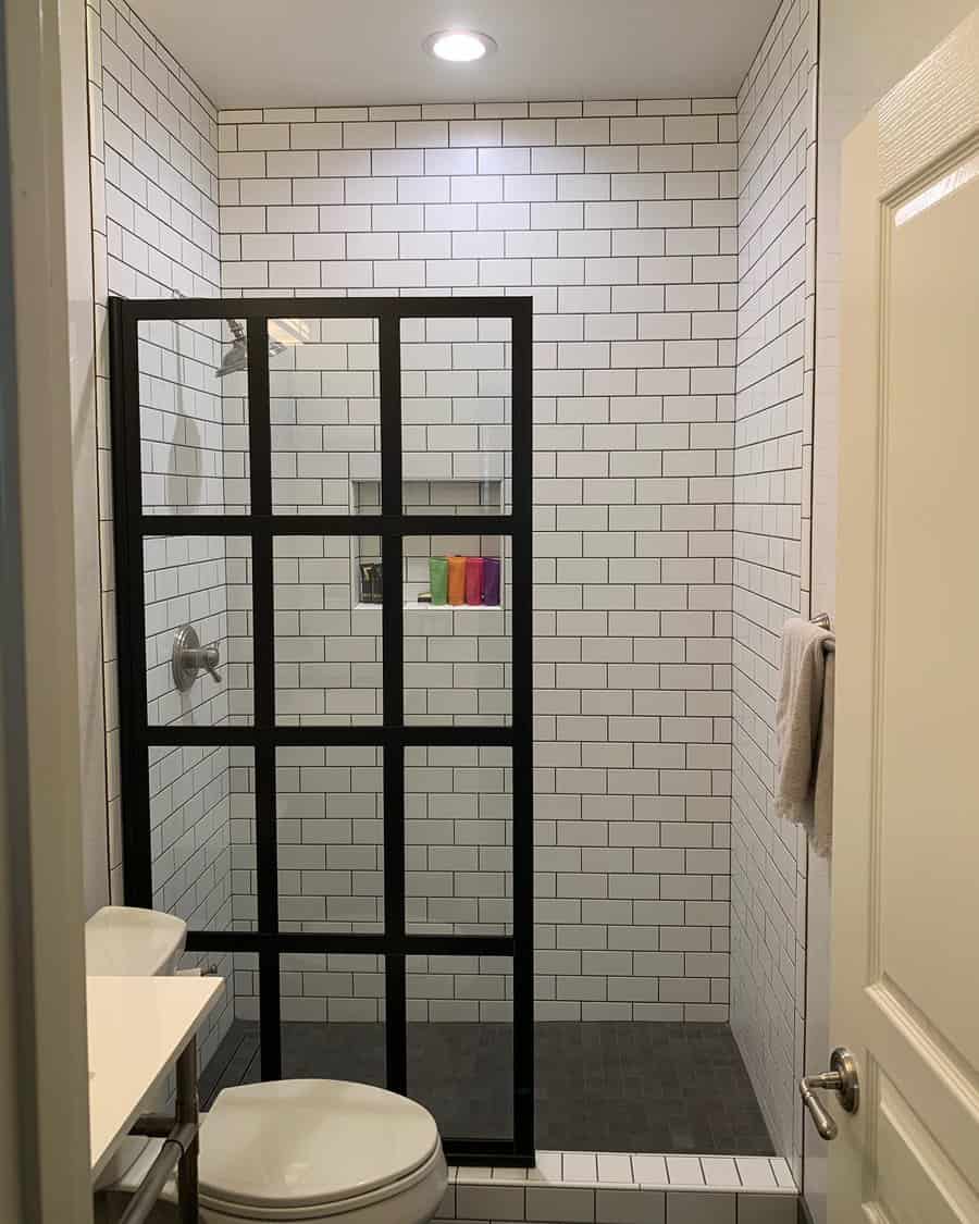 Walk in shower with black and white subway tile