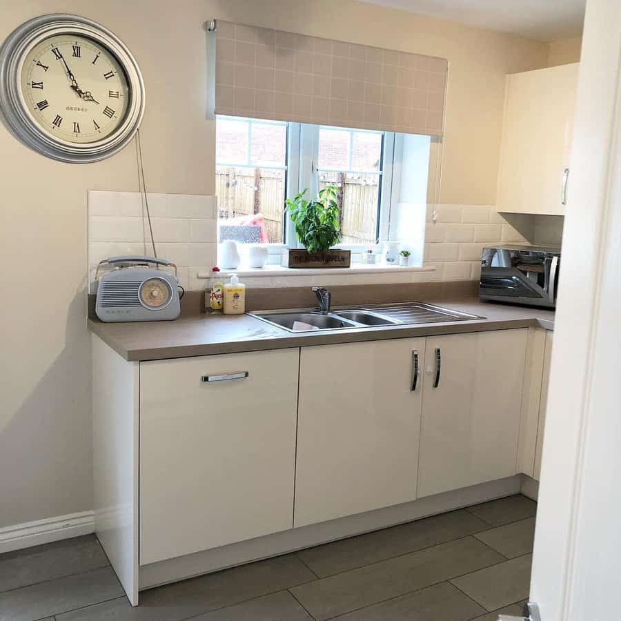 White kitchen with grey roman shade 