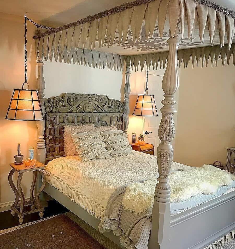 Elegant bedroom with carved four-poster bed, fringed canopy, plush pillows, side tables, and pendant lamps, creating a cozy and inviting atmosphere