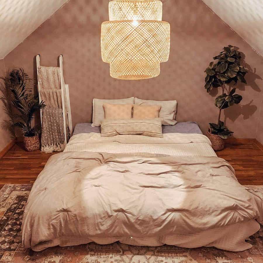 Cozy boho attic bedroom with warm neutrals, soft bedding, and woven textures. A statement light fixture and greenery add natural charm.