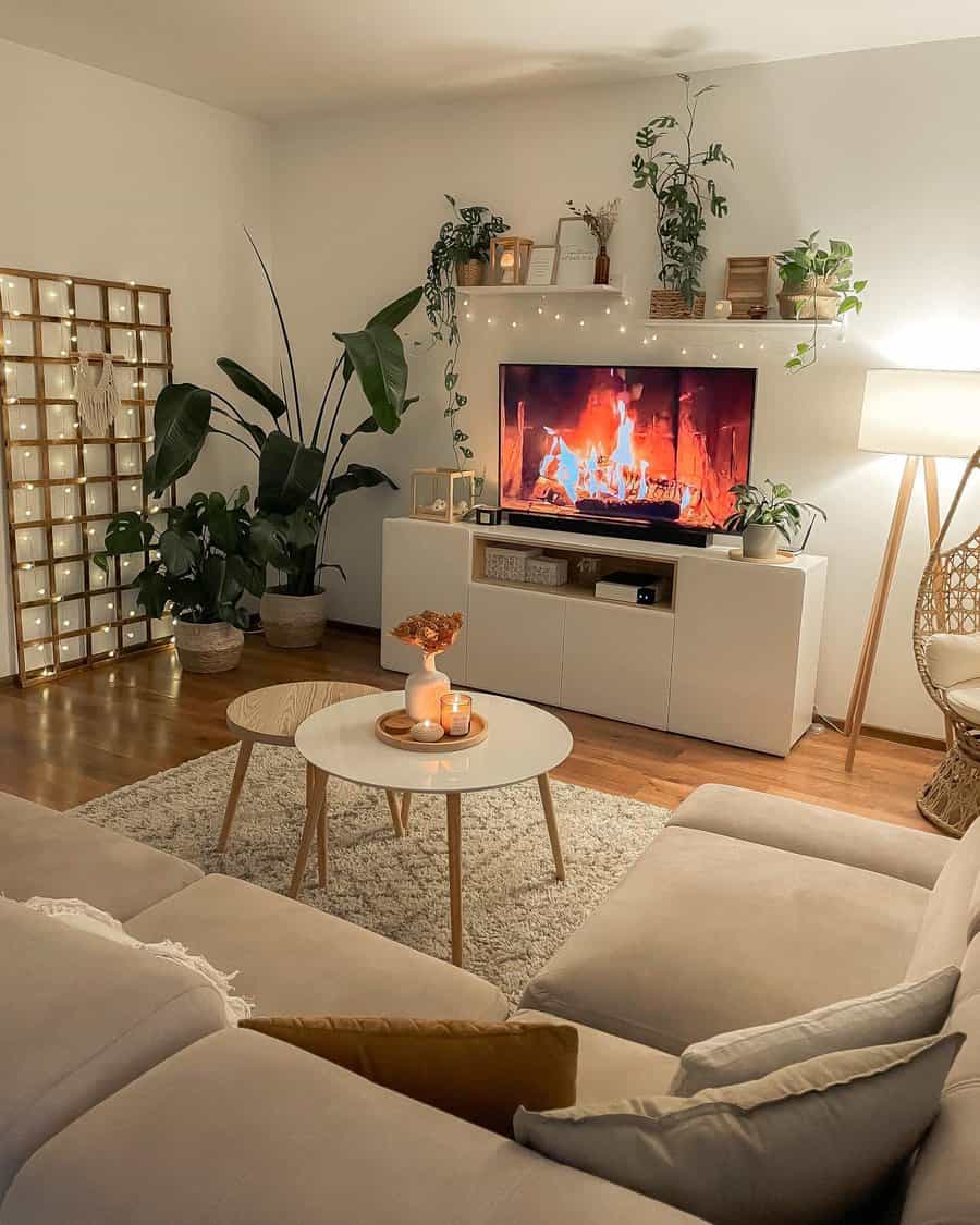 Cozy living room with fireplace on TV, plants, and warm lighting