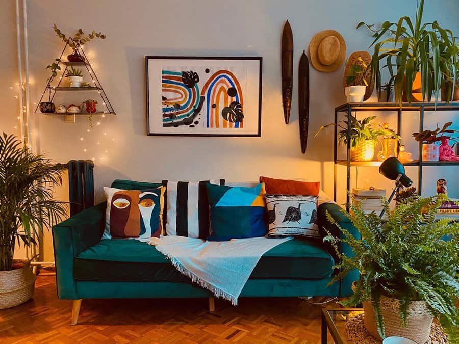 Vibrant boho living room with a deep green sofa, eclectic pillows, bold wall art, warm lighting, and lush greenery for a cozy, artistic vibe