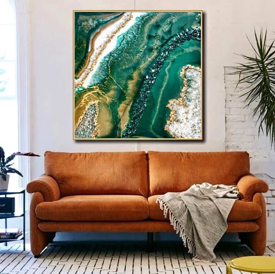 Resin art piece over a vibrant orange sofa with a throw