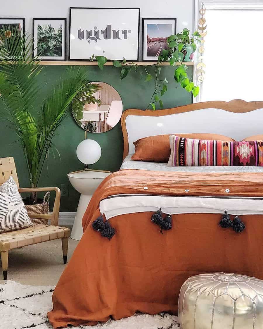 Boho Zen bedroom with earthy tones, a wooden bed, green accent wall, layered textiles, and plants for a serene, cozy vibe