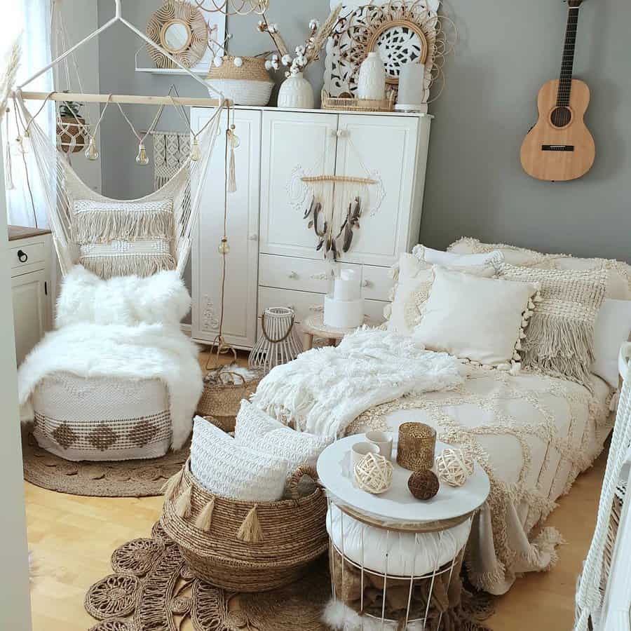 Bohemian-style bedroom with plush textures, a hanging chair, dreamcatcher, and acoustic guitar on the wall in neutral and white tones