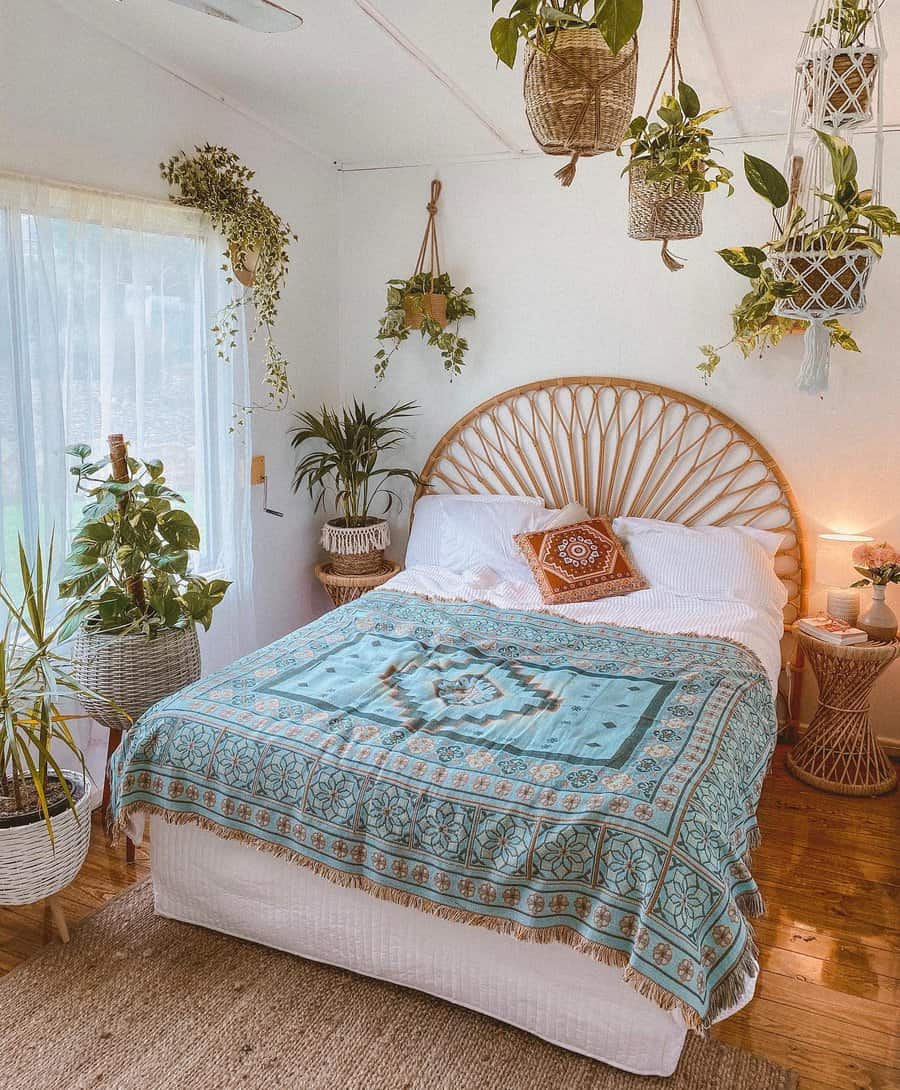 Boho Zen bedroom with a rattan headboard, hanging plants, sheer curtains, and a patterned throw for a fresh and tranquil atmosphere