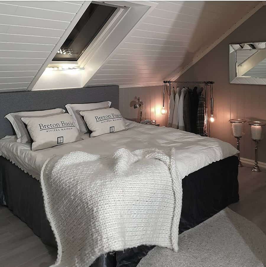 Chic attic bedroom with a monochrome palette, soft textures, and ambient lighting. A skylight and cozy knit throw add warmth and elegance.