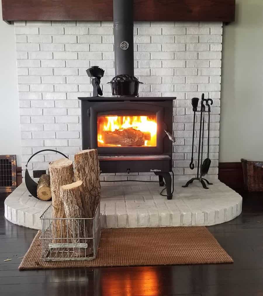 Cozy wood stove with fire on brick hearth
