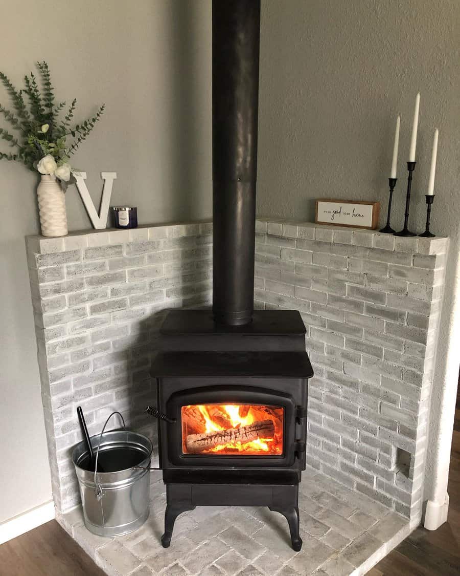 Modern stove with lit fire on a white brick hearth