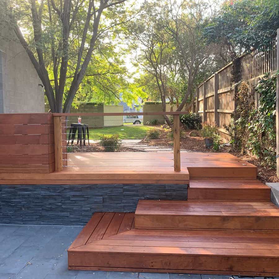 Wooden deck with stone skirting and trees in the background