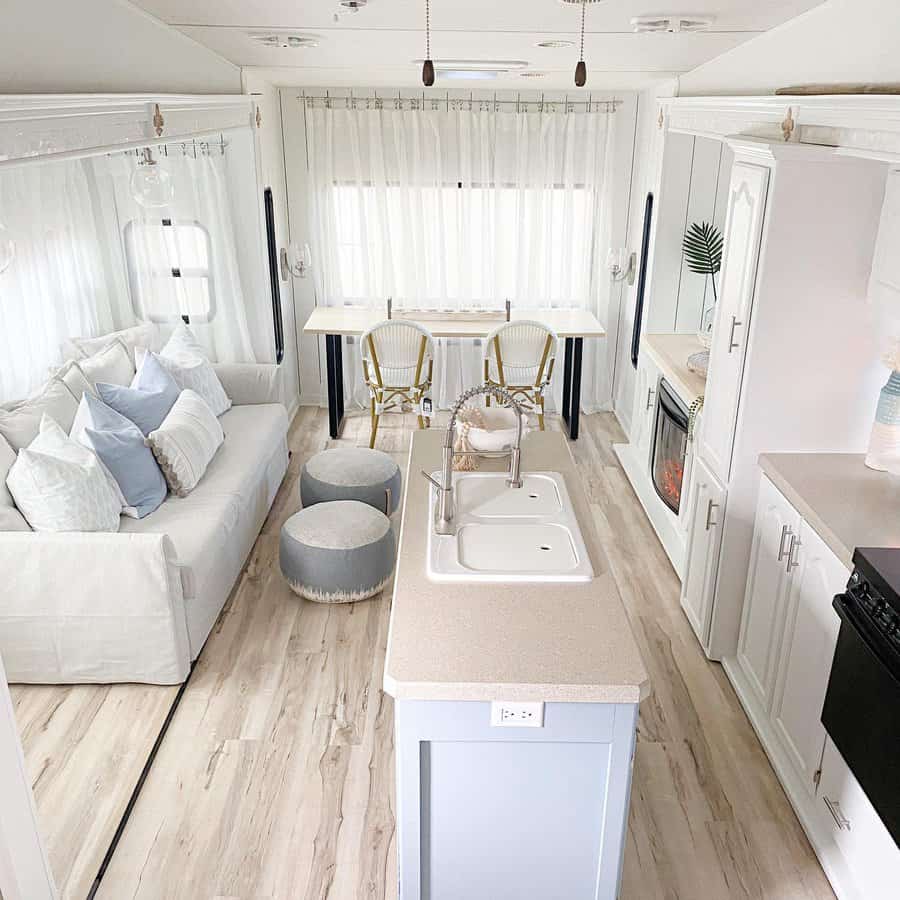 Spacious and bright RV interior with white decor and seating area