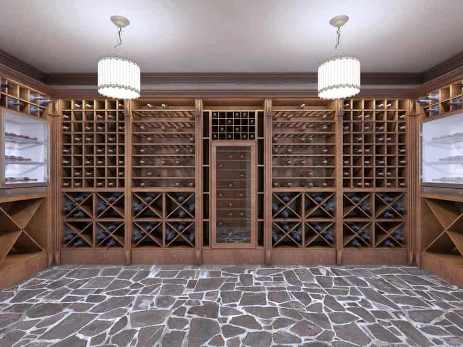 Luxurious wine cellar with wooden racks filled with wine bottles, stone-tiled floor, and two pendant lights