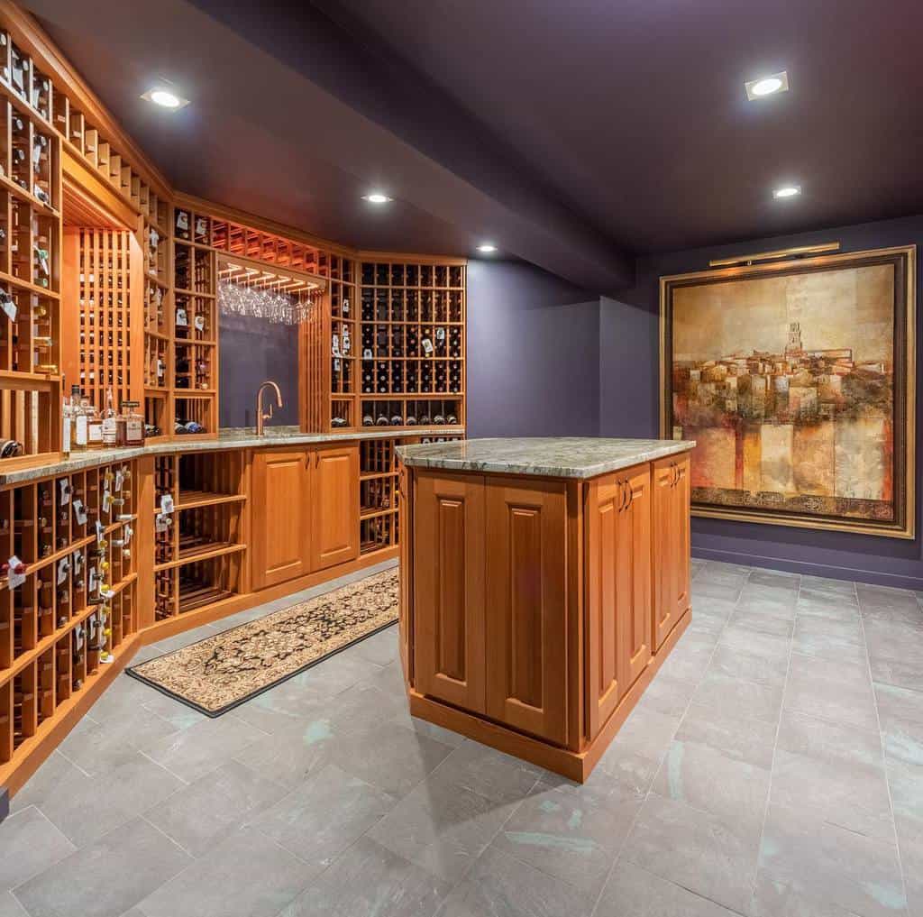 Wine cellar with wooden shelves filled with bottles, a central island, dark flooring, and a large painting on the wall