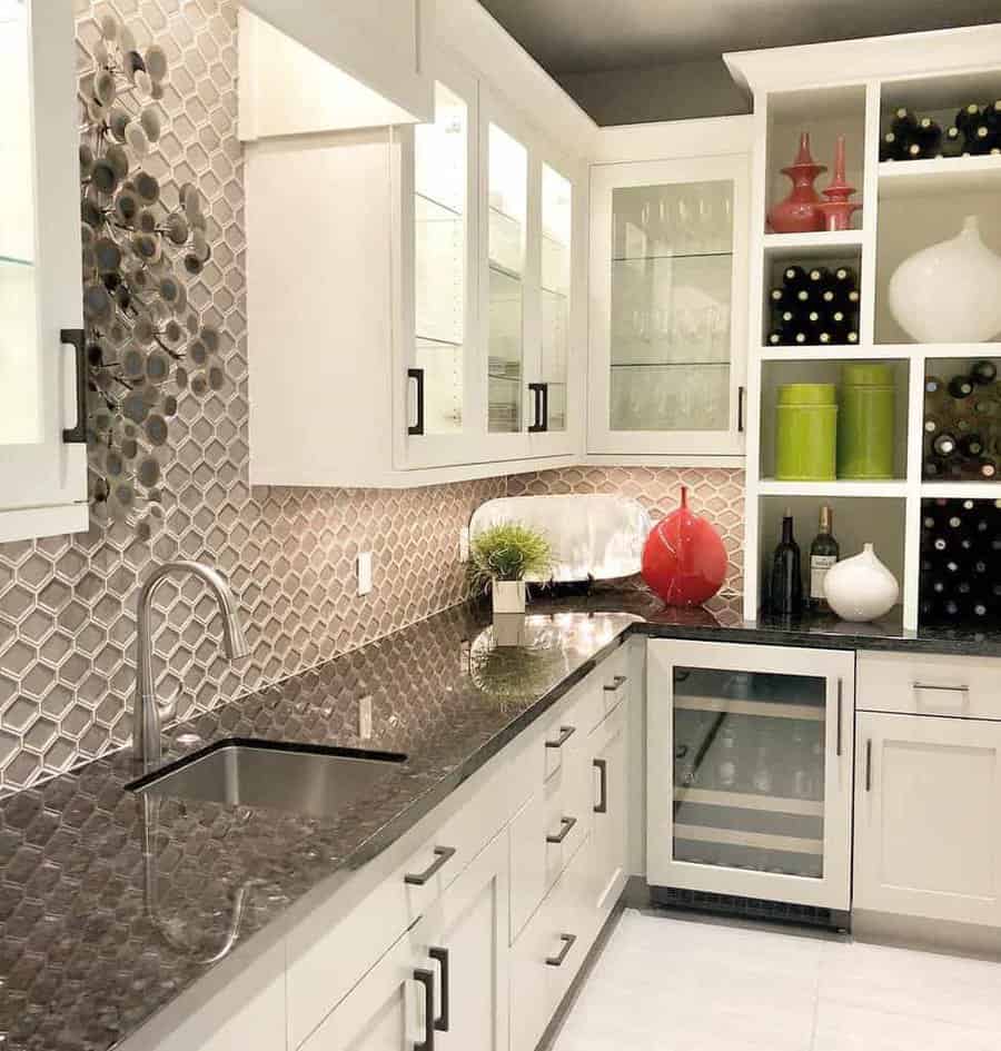 Modern kitchen with white cabinets, hexagonal tile backsplash, wine rack, glass cabinets, and stainless steel sink