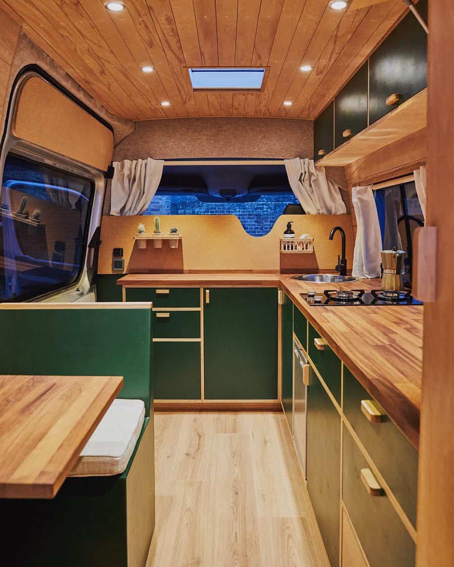 Camper interior with green cabinets and wooden details