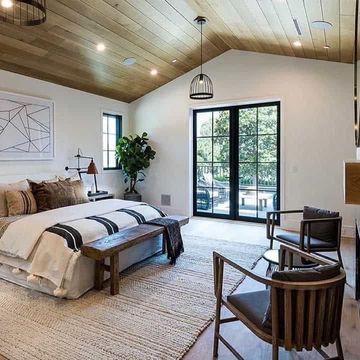 Rustic bedroom with vaulted ceiling and balcony