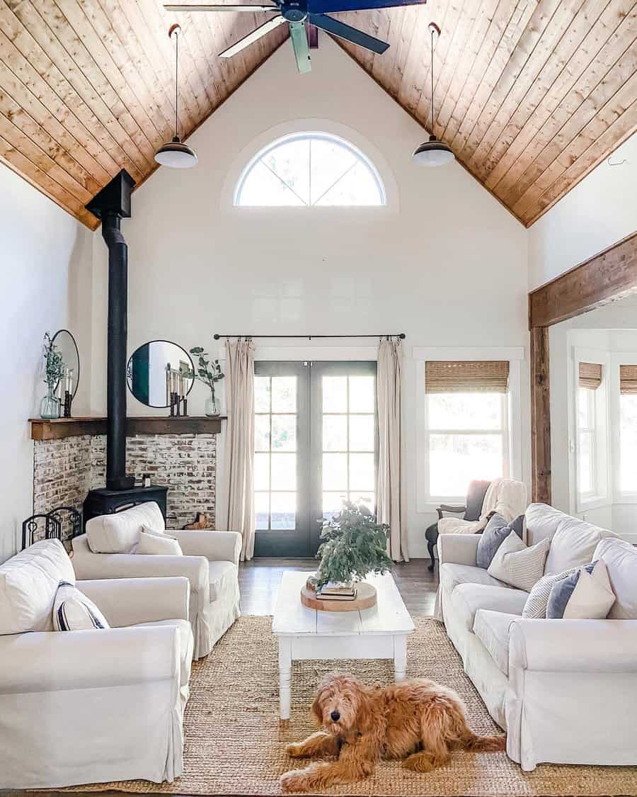 Cozy living room with vaulted wood ceiling, white sofas