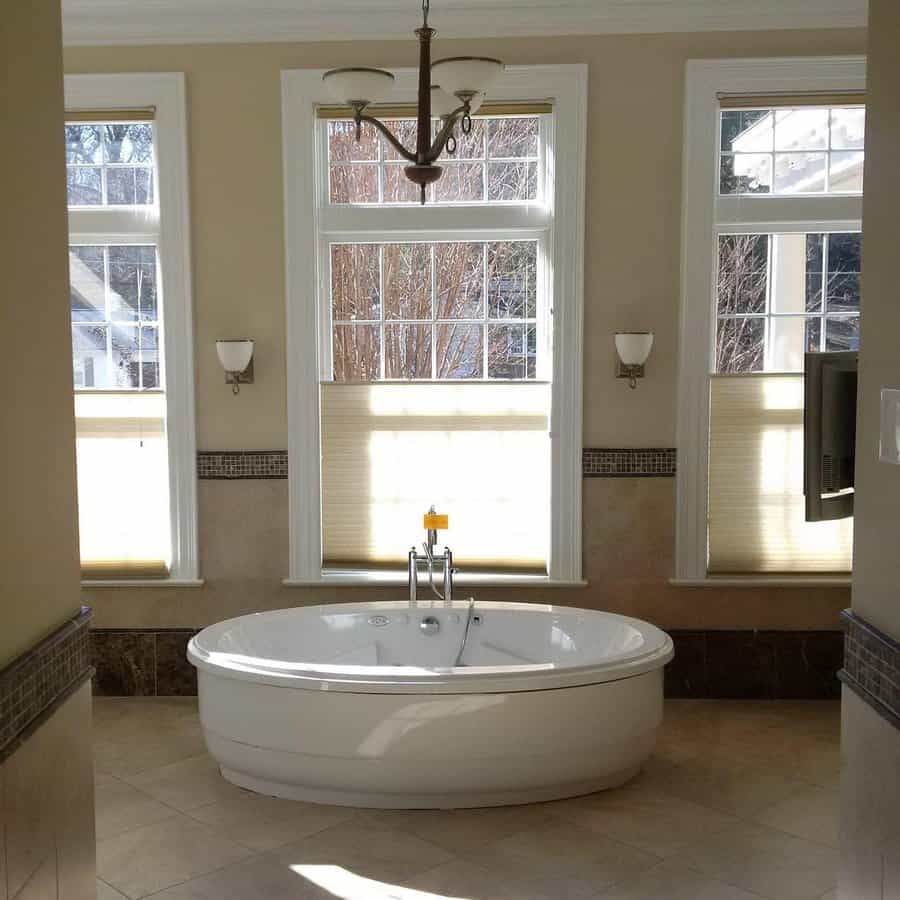 Bright bathroom with chandelier and corner tub