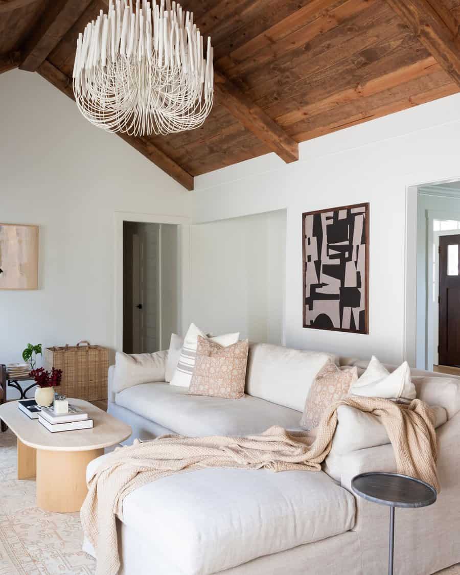 Modern living room with beige sectional, abstract art, and a large white chandelier