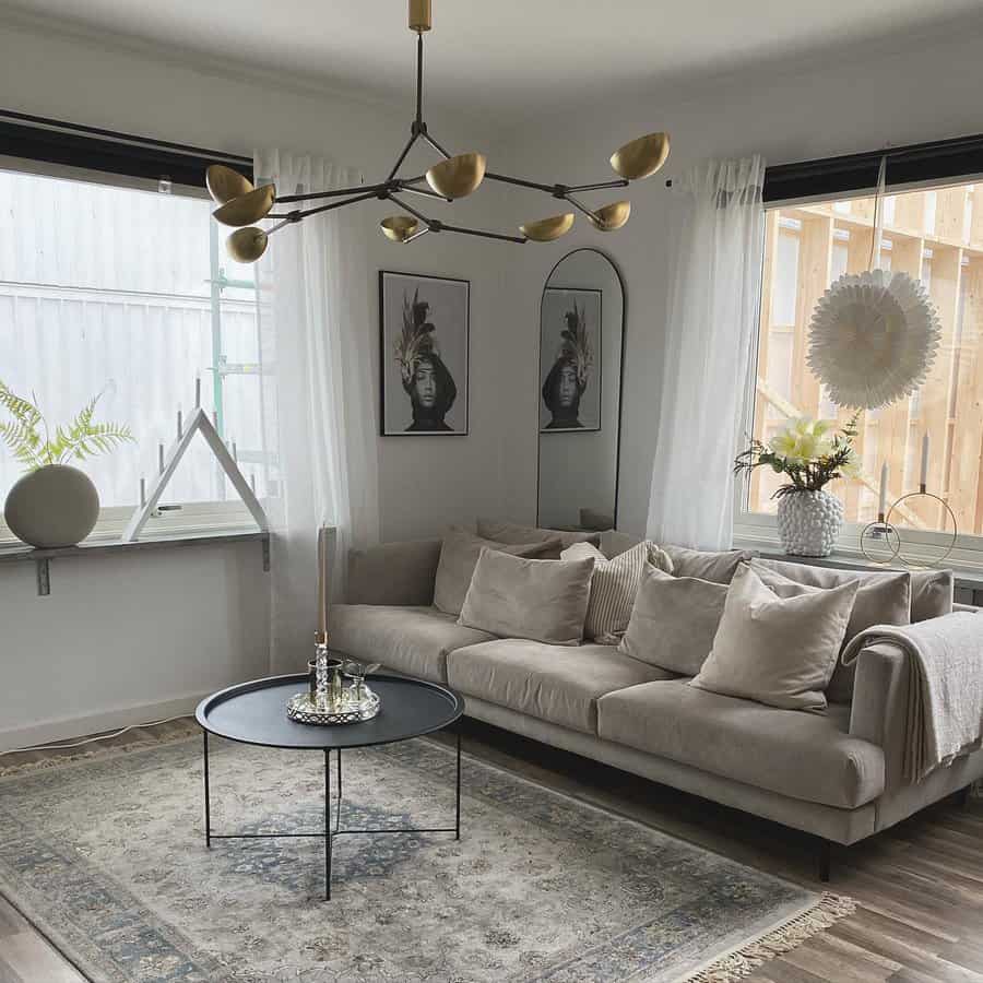 Modern living room with a beige sofa, round coffee table, and modern chandelier