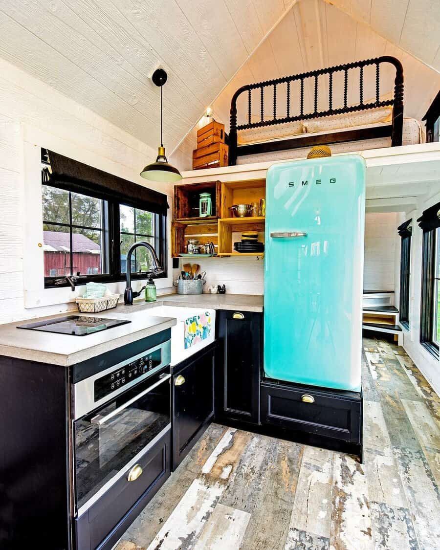 Stylish tiny house kitchen with a vintage fridge and loft above