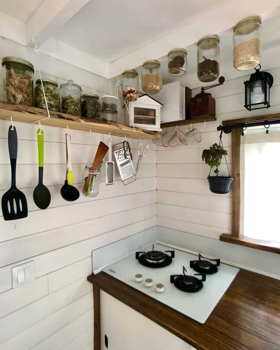 Compact kitchen corner with hanging utensils and jars