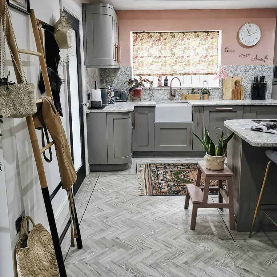 Chevron-patterned kitchen flooring in a light wood tone adds texture and elegance, complementing the warm, rustic, and modern kitchen decor