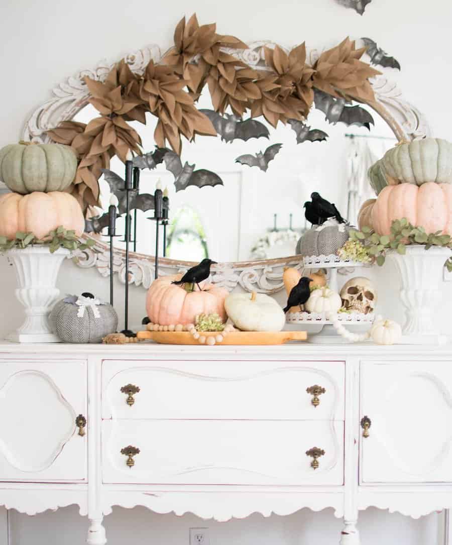 Halloween-themed mantel with pumpkins, crows, bats, and a decorative mirror