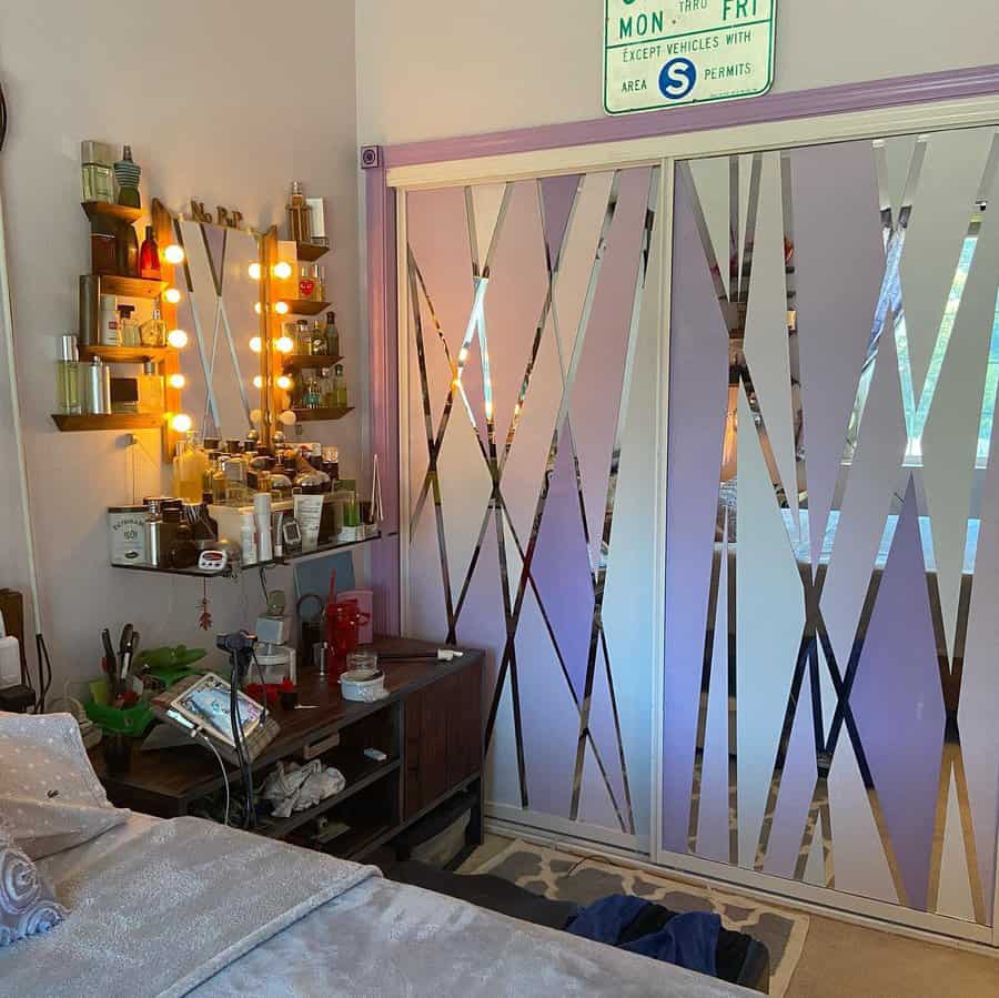 Modern sliding closet doors with mirrored geometric accents add a bold and stylish touch to this eclectic bedroom with a vanity setup